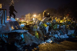  В какой-то момент раздается клич о поиске добровольцев, готовых притащить на баррикады автобус. В одном из дворов демонстранты находят брошенный микроавтобус и пытаются на руках его вынести на баррикады. Это не получается, тогда его решают катить.
