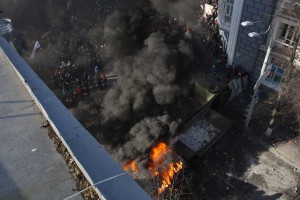 Протестующие стоят среди дыма во время столкновений с полицией в Киеве, 18 февраля 2014 года.