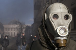 антиправительственный демонстрант в маске газа во время столкновений с членами МВД в Киеве, 18 февраля 2014 года.