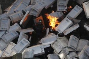 Полицейские пытаются избежать пламя из бутылки с зажигательной смесью во время столкновений с участниками антиправительственных демонстраций перед парламентом Украины в Киеве, 18 февраля 2014 года.