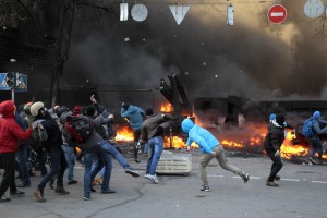 Спецназовцы уносят раненого коллегу, который пострадал во время столкновений между спецназом и антиправительственными манифестантами на Майдане Незалежности.