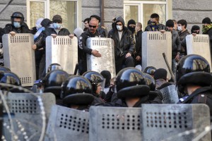 Пророссийские демонстранты стоят перед ОМОНовцами у здания регионального управления в Донецке, 6 апреля 2014. 