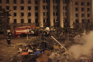 2 мая 2014 года. Одесса. Пожарный смывает копоть и грязь с асфальта перед Домом профсоюза, в котором сгорело заживо более 30 пророссийских активистов и сторонников федерализации Украины. Фотография: AP Photo/Sergei Poliakov
